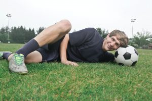 Soccer Player resting on a ball